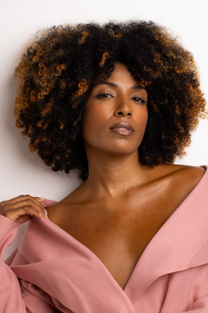 Close-up of a stylish woman with natural curly hair and elegant expression.